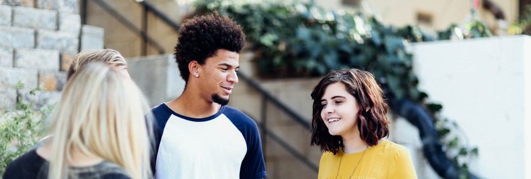 women and man talking outside the building