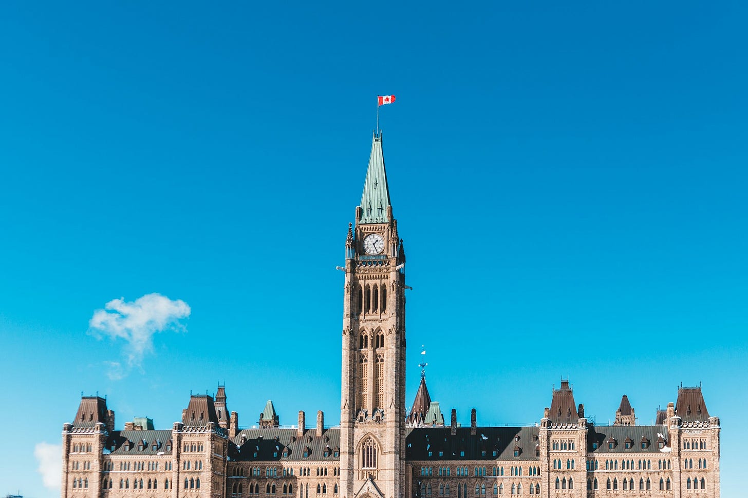 Wide‑angle interior shot of Canada’s Parliament (by Erik Mclean). Symbolizes MPs’ bridge between Ottawa and constituents during recess.