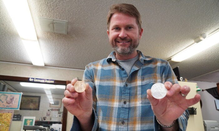 Gabe Wright, co-owner of Coin Heaven in Cottonwood, Ariz., holds gold and silver coins, two of the hottest selling items on March 20, 2023. (Allan Stein/The Epoch Times)