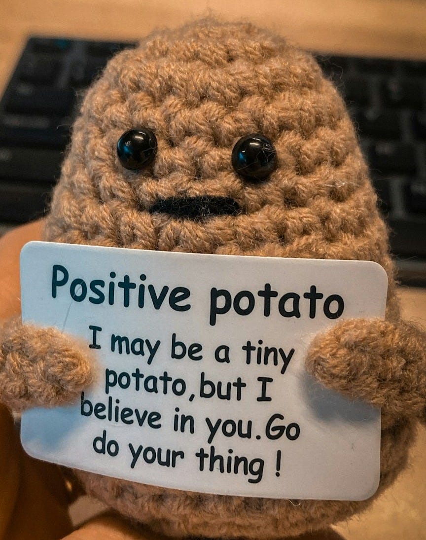 a person holding a small stuffed animal with a sign on it a person holding a small stuffed animal with a sign on it