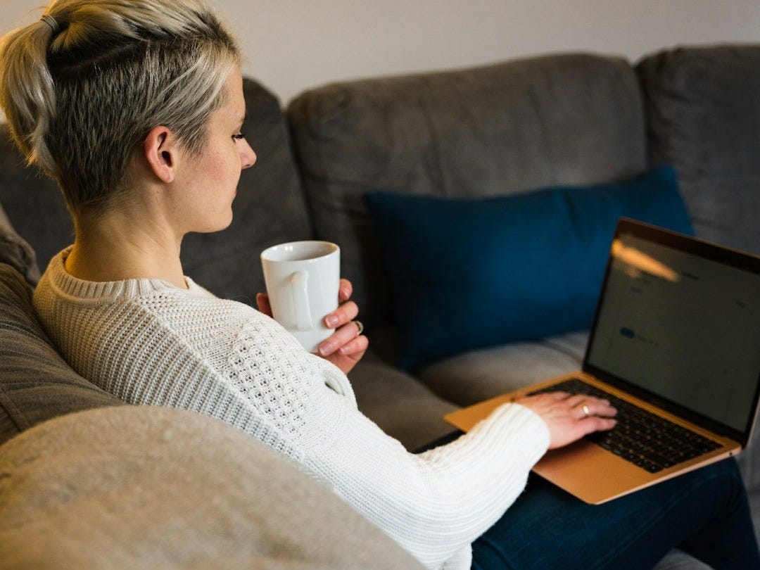 woman in white sweater using macbook air woman in white sweater using macbook air