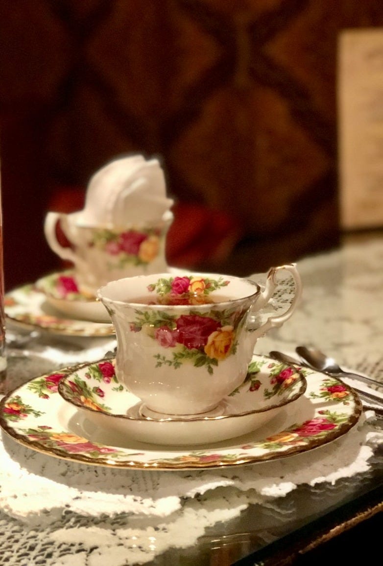 clear drinking glass on white floral ceramic saucer clear drinking glass on white floral ceramic saucer