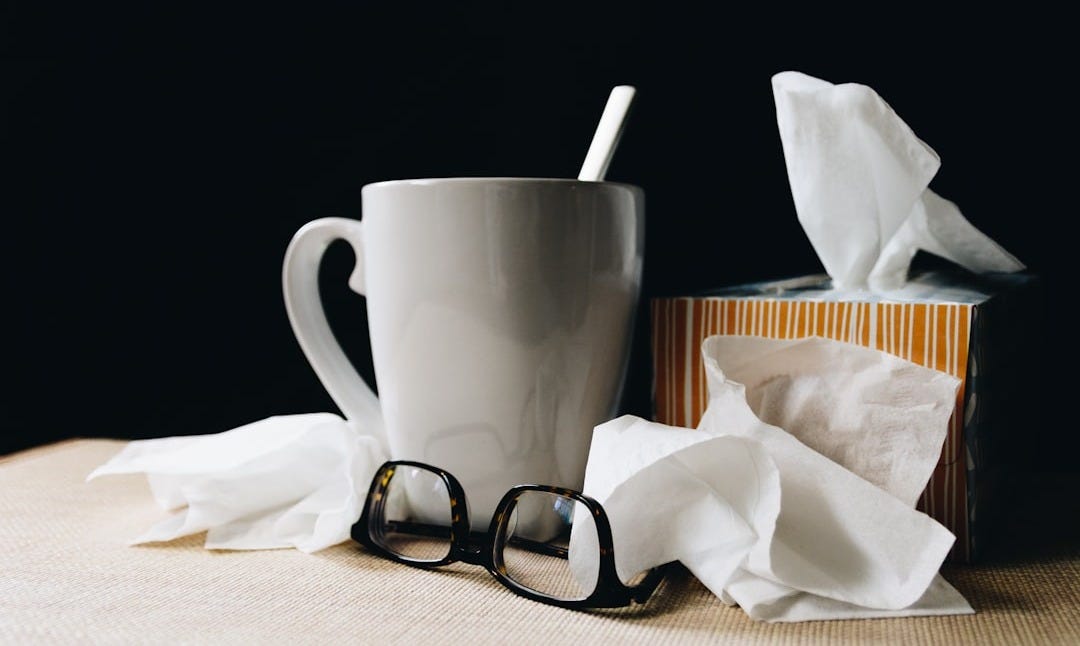 white ceramic mug on white table beside black eyeglasses white ceramic mug on white table beside black eyeglasses