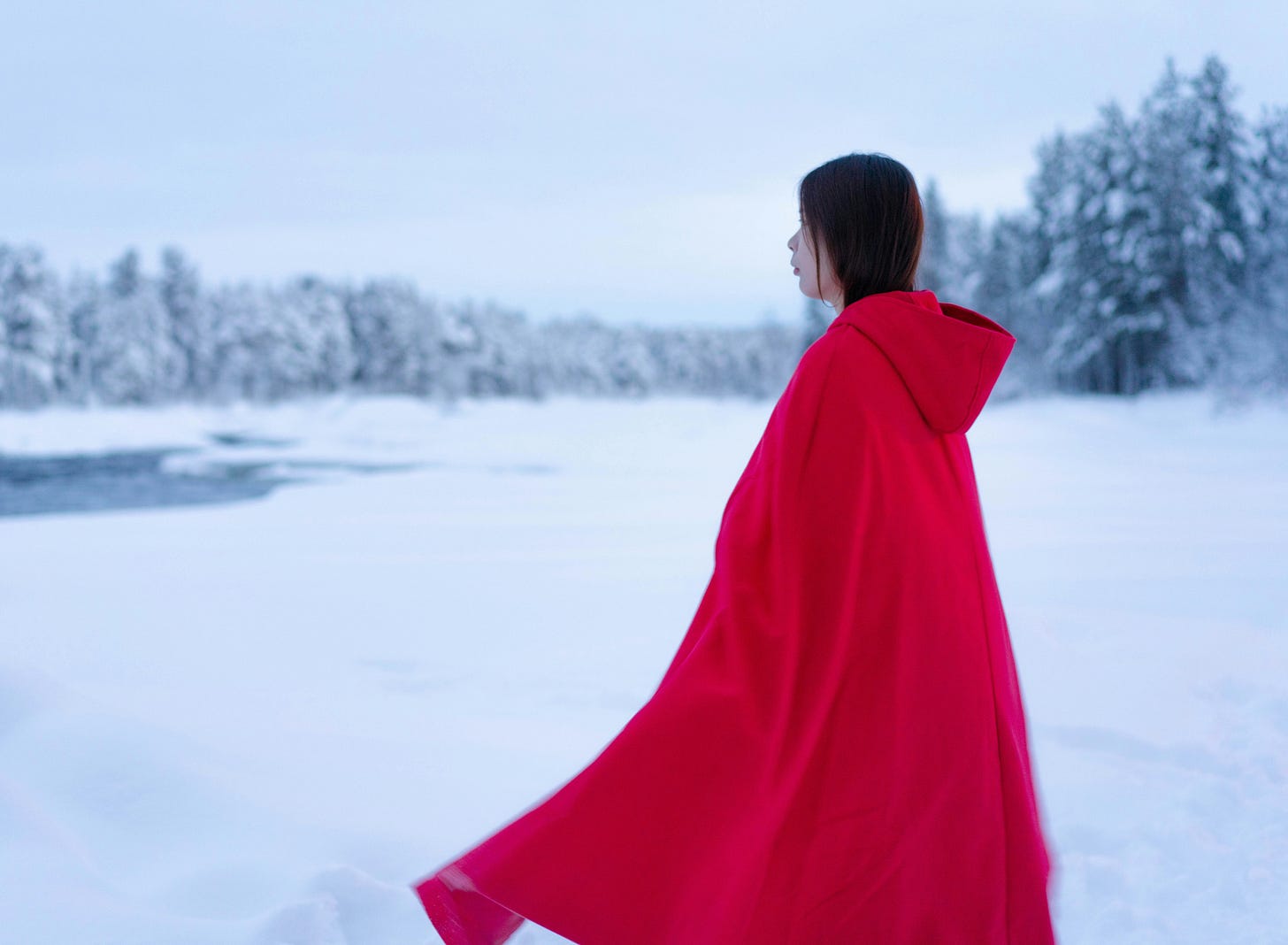 woman in red coat standing outside in snow