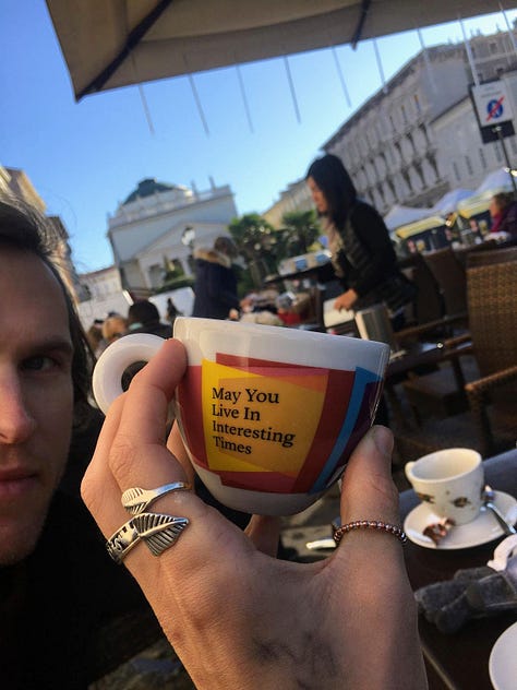 First photo shows a hand with silver rings on the fingers holding a mostly yellow espresso cup bearing the words "may you live in interesting times"; the second image is the author with long, lank straight hair; in the third image, the author is struggling with an over-filled bag of shopping on the footpath beside the river Ouse
