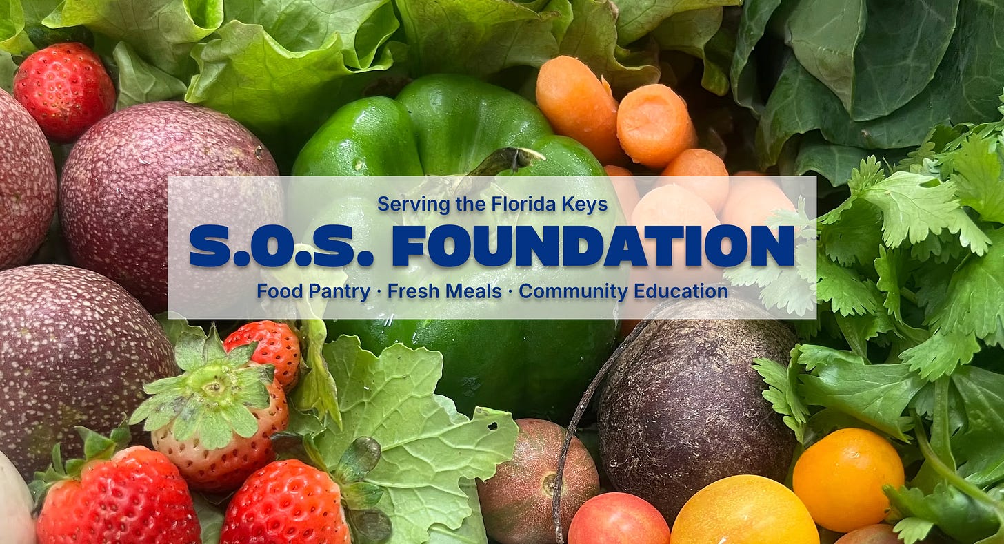 Fresh strawberries, peppers, carrots, and greens behind an S.O.S. Foundation Florida Keys banner