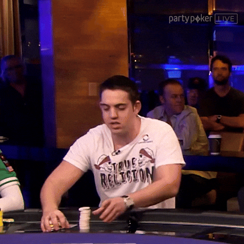 A poker player pushing all his chips into the center for an all-in bet.
