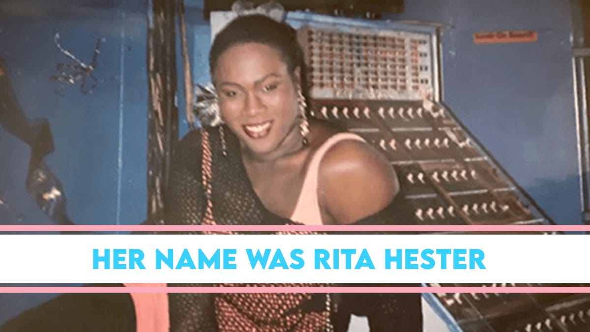 Graphic honoring Transgender Day of Remembrance featuring a smiling woman posing in front of an audio or control panel, with overlay text reading ‘Her Name Was Rita Hester’ in blue on a pink, white, and blue stripe inspired by the transgender pride flag.