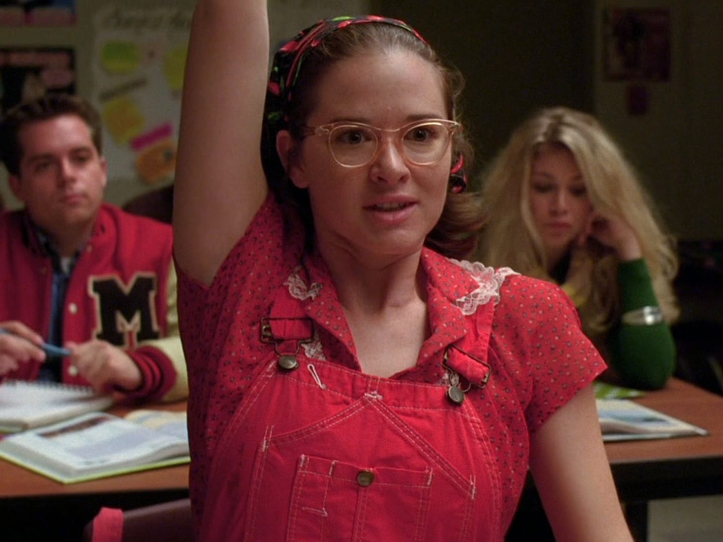 Sarah Drew wearing red overalls and glasses on 'Glee.'