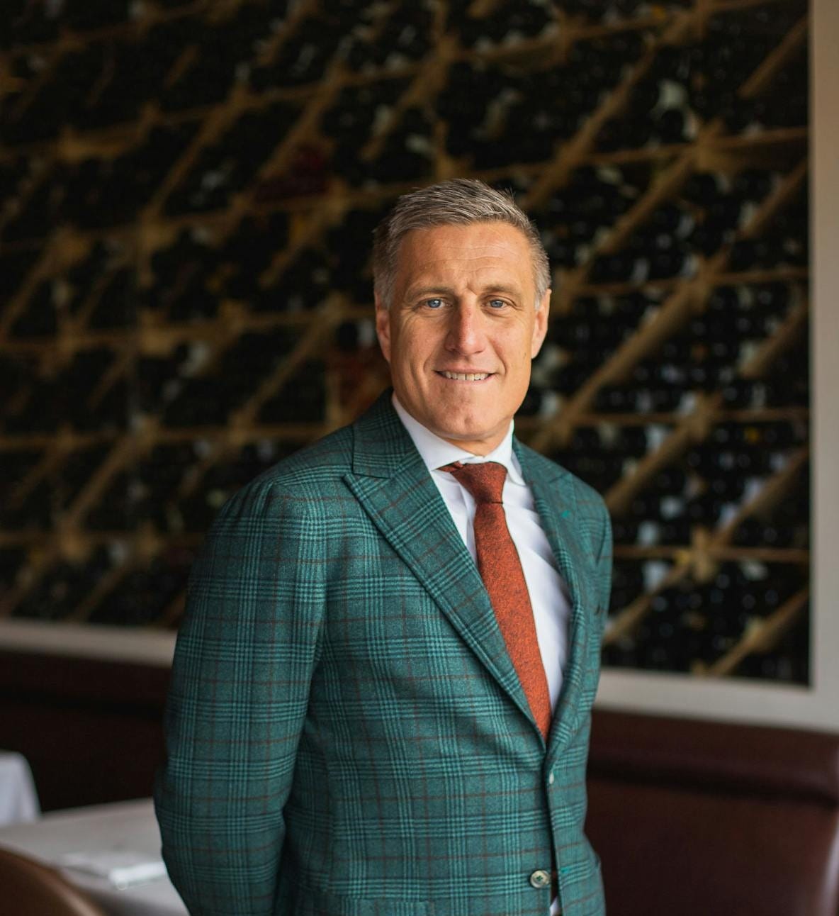 a person wearing a suit and tie smiling at the camera