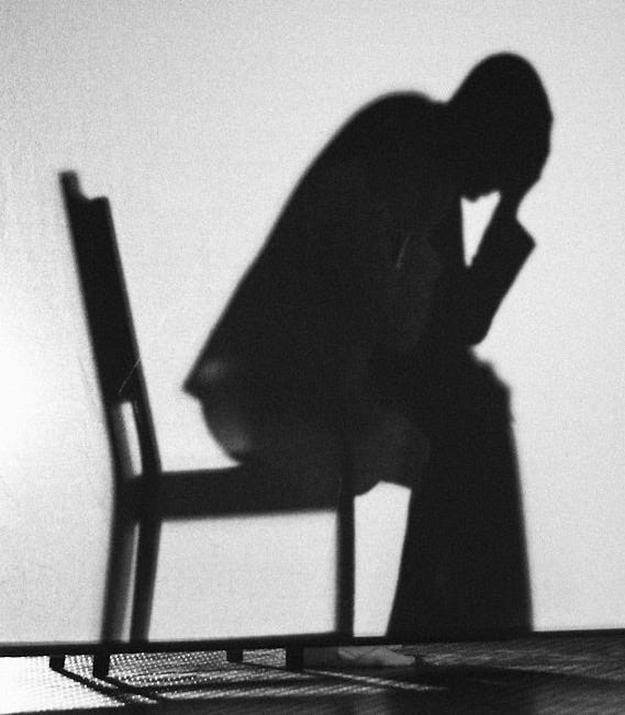 A black and white photo of a person sitting in a chair