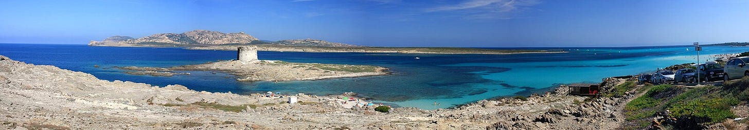 Vista panoramica della baia in località Stintino, con le acque di varie tonalità di azzurro di fronte alla spiaggia La Pelosetta. Vista panoramica della baia in località Stintino, con le acque di varie tonalità di azzurro di fronte alla spiaggia La Pelosetta.