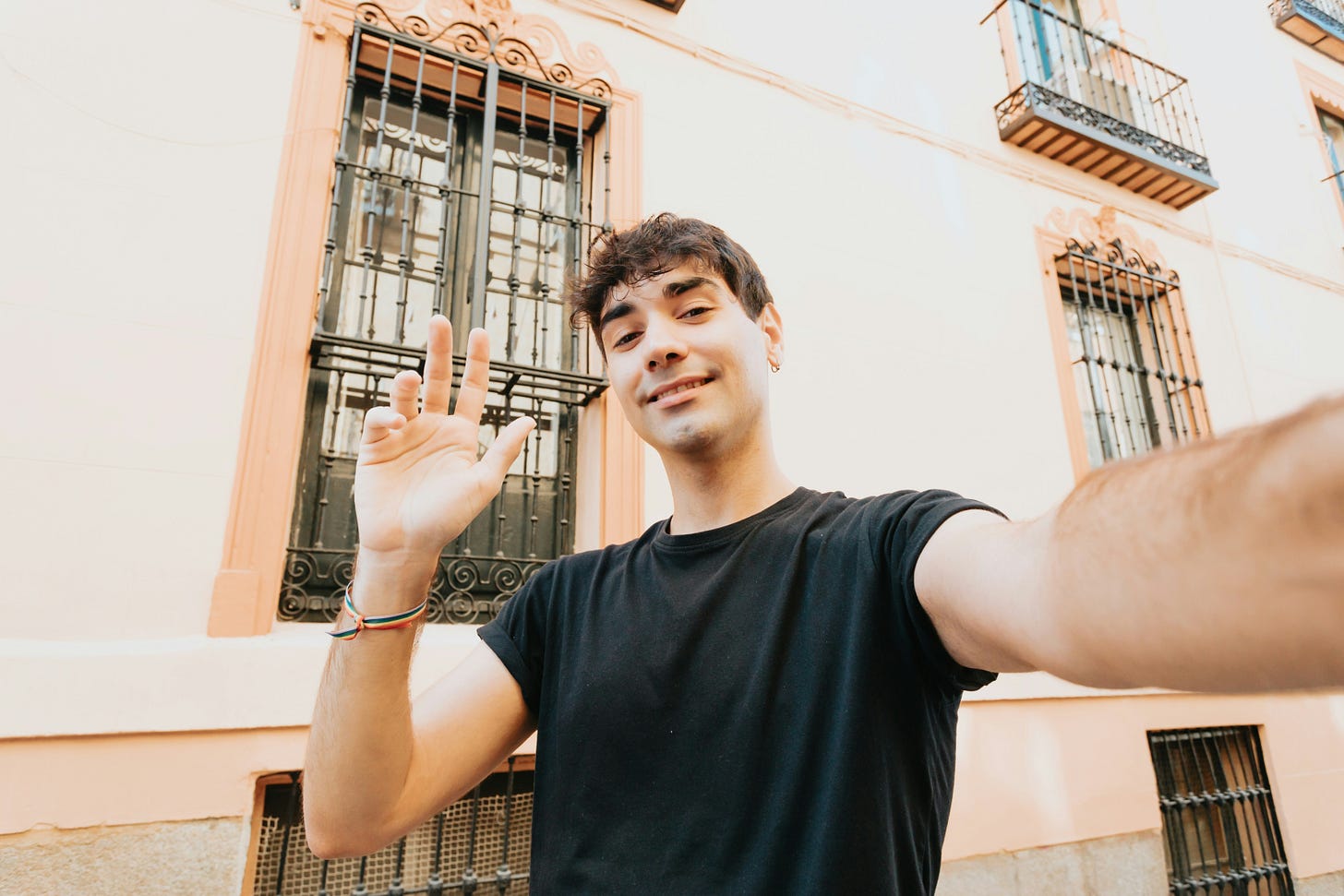 Man in a black shirt waving. 