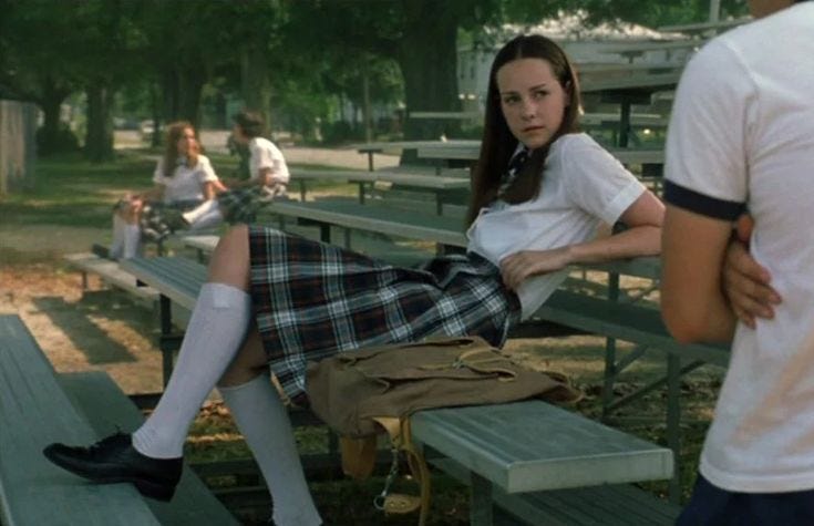 This may contain: a woman sitting on top of a bench next to a man in a white shirt