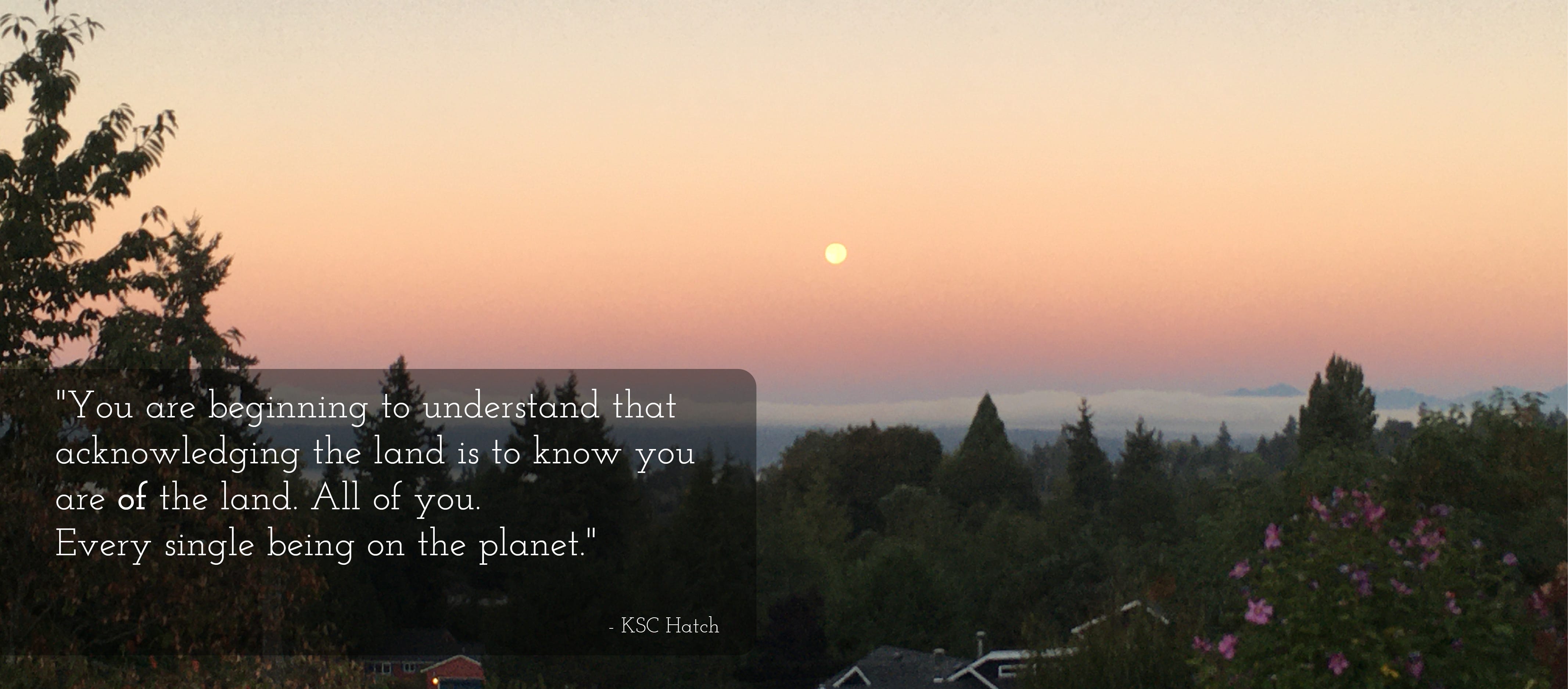 Photo of the setting sun towards the horizon on a smoky day. The sky is peachy coloured, with clouds resting along the horizon. In the forground are black sillhouettes of trees. A quote in white text on a black rectangle is on the left side of the image. It reads: You are beginning to recognise that acknowledging the land is to know you are of the land. All of you. Every single being on the planet."