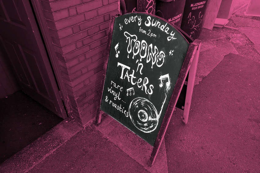An A-board outside a pub advertising Toons and Taters -- rare vinyl and roasties.
