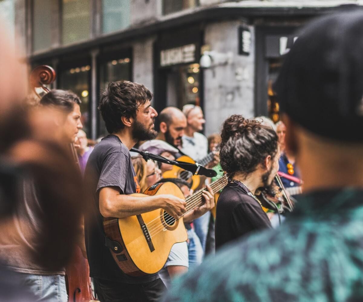 A small string band plays on a busy Madrid street