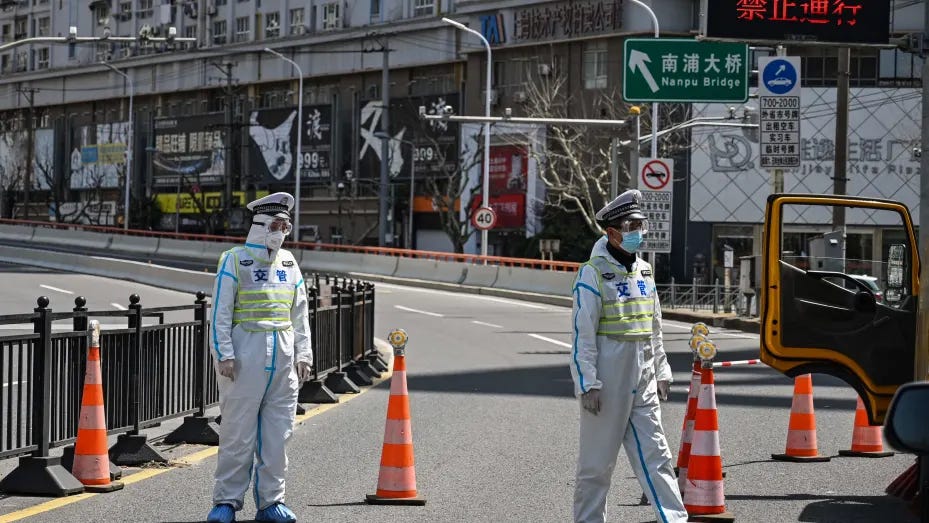 Transit officers, wearing a protective gear, control access to a bridge in the direction of Pudong district in lockdown as a measure against the Covid-19 coronavirus, in Shanghai on March 29, 2022. (Photo by Hector RETAMAL / AFP) (Photo by HECTOR RETAMAL/AFP via Getty Images)