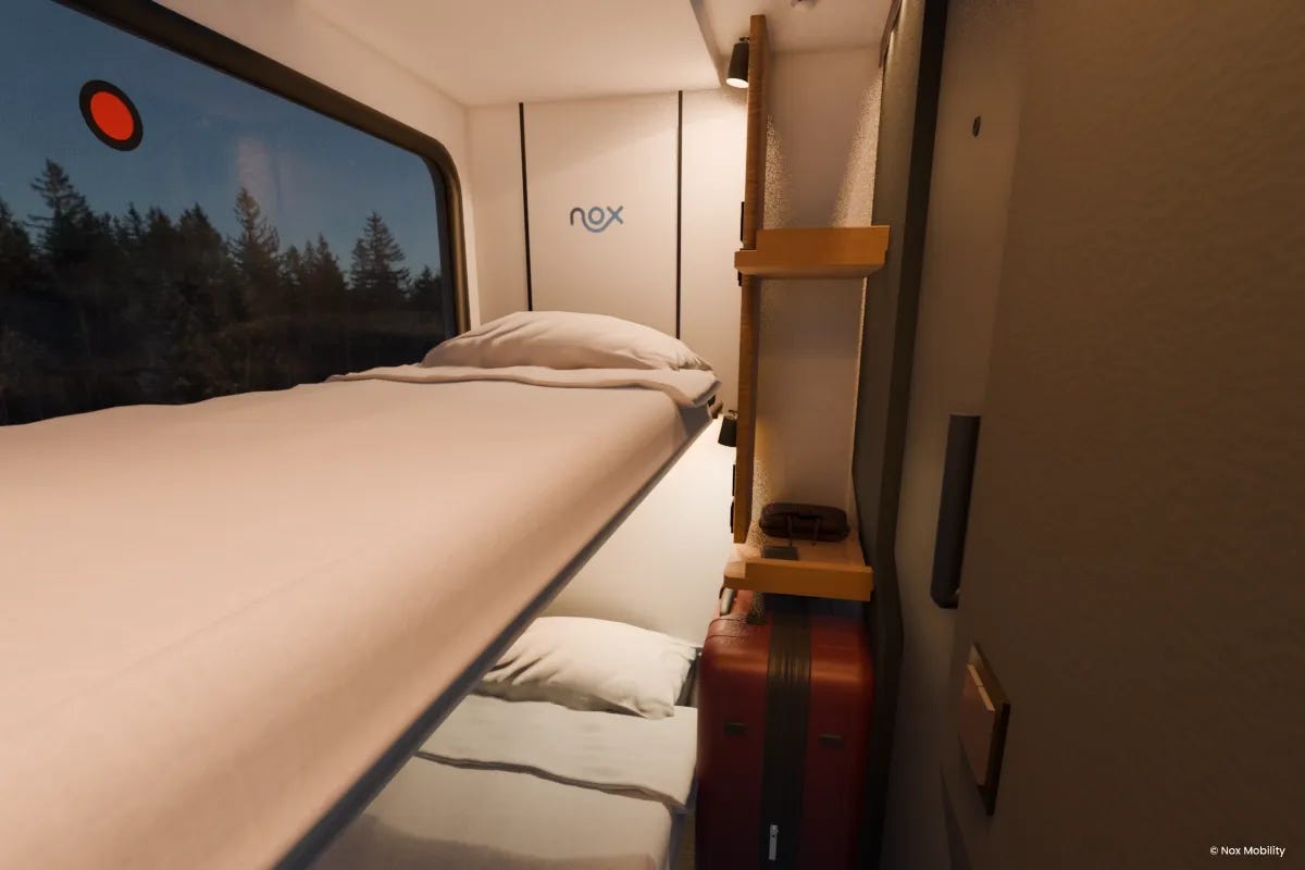 Une image d’une cabine de train de nuit innovante, à l’éclairage tamisé, avec deux lits et une grande fenêtre.