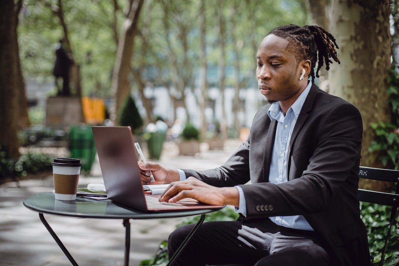 Black man working at an outdoor cafe. Second Guess newsletter by Ama Udofa Black man working at an outdoor cafe. Second Guess newsletter by Ama Udofa