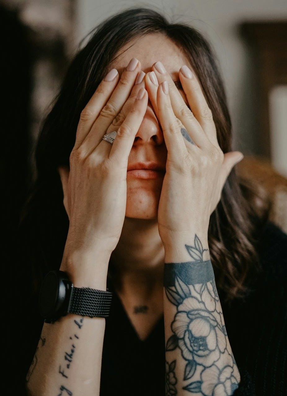 woman in black long sleeve shirt covering her face woman in black long sleeve shirt covering her face
