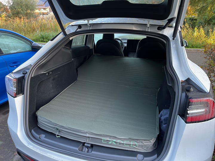 Bike rack on a Tesla Model Y. Sleeping mat inside Tesla Model Y.