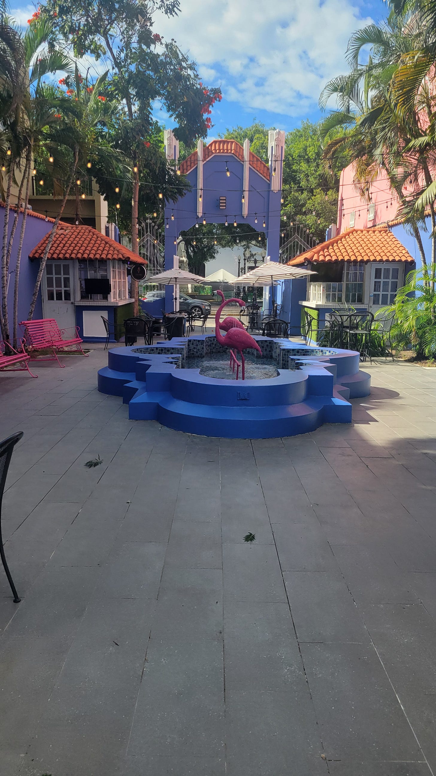 Courtyard of Fox hotel with pink flamingos in a blue fountain, blue walls, and lots of tropical trees Courtyard of Fox hotel with pink flamingos in a blue fountain, blue walls, and lots of tropical trees