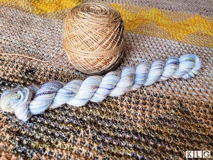 Koigu KPM 100% Merino wool in pale caramel brown and KPPM 100% Merino Wool in white with browns. blues, and creams