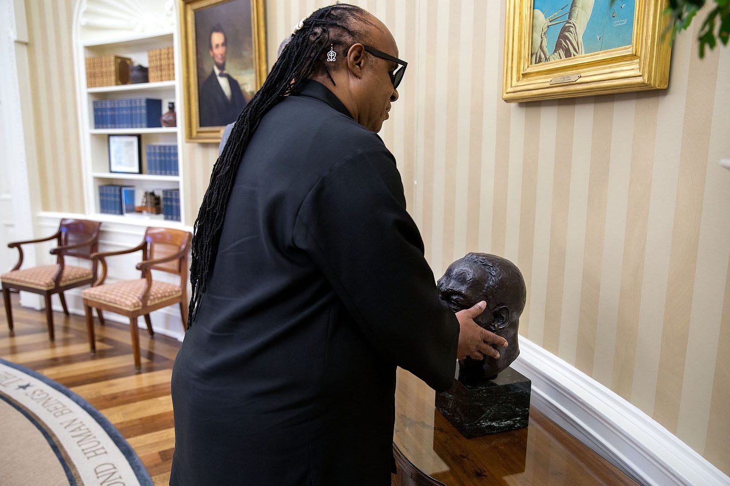 August 5, 2016: In the Oval Office, President Obama describes the iconic bust of Dr. Martin Luther King Jr. and other items to a visiting Stevie Wonder. August 5, 2016: In the Oval Office, President Obama describes the iconic bust of Dr. Martin Luther King Jr. and other items to a visiting Stevie Wonder.