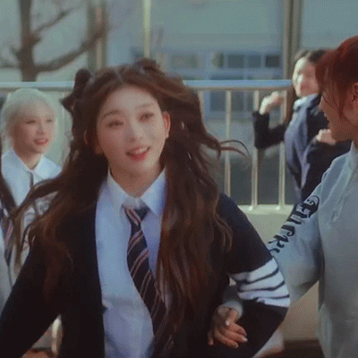 the members of kpop group BILLLIE in their "EUNOIA" music video; the girls are skipping outside of their high school in the video