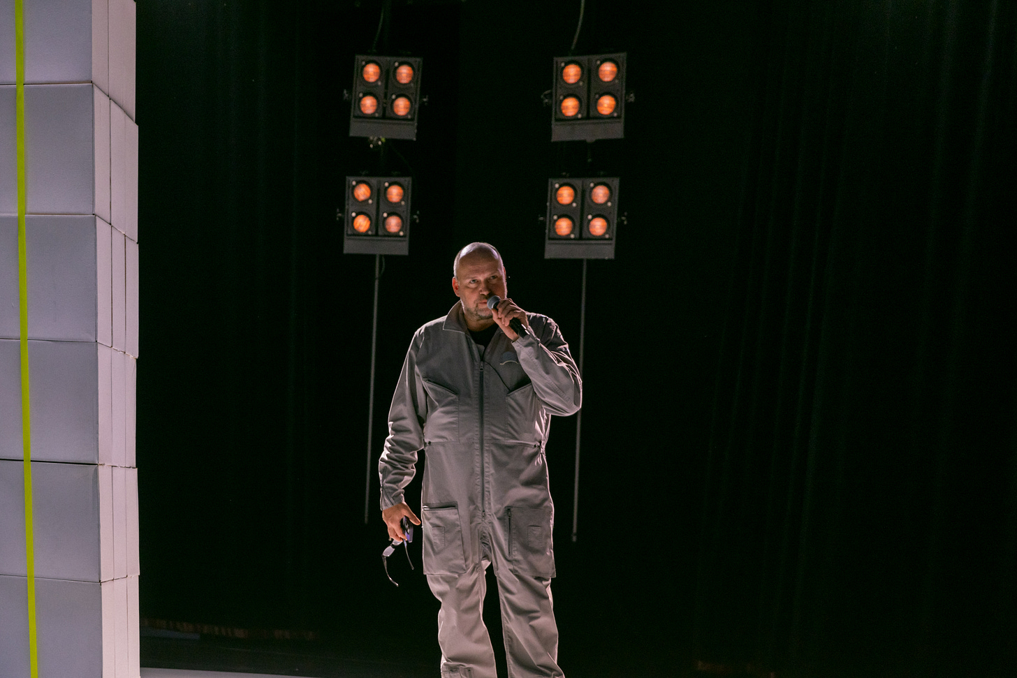 Daniel Wetzel stands on stage wearing a pilot's jumpsuit.
