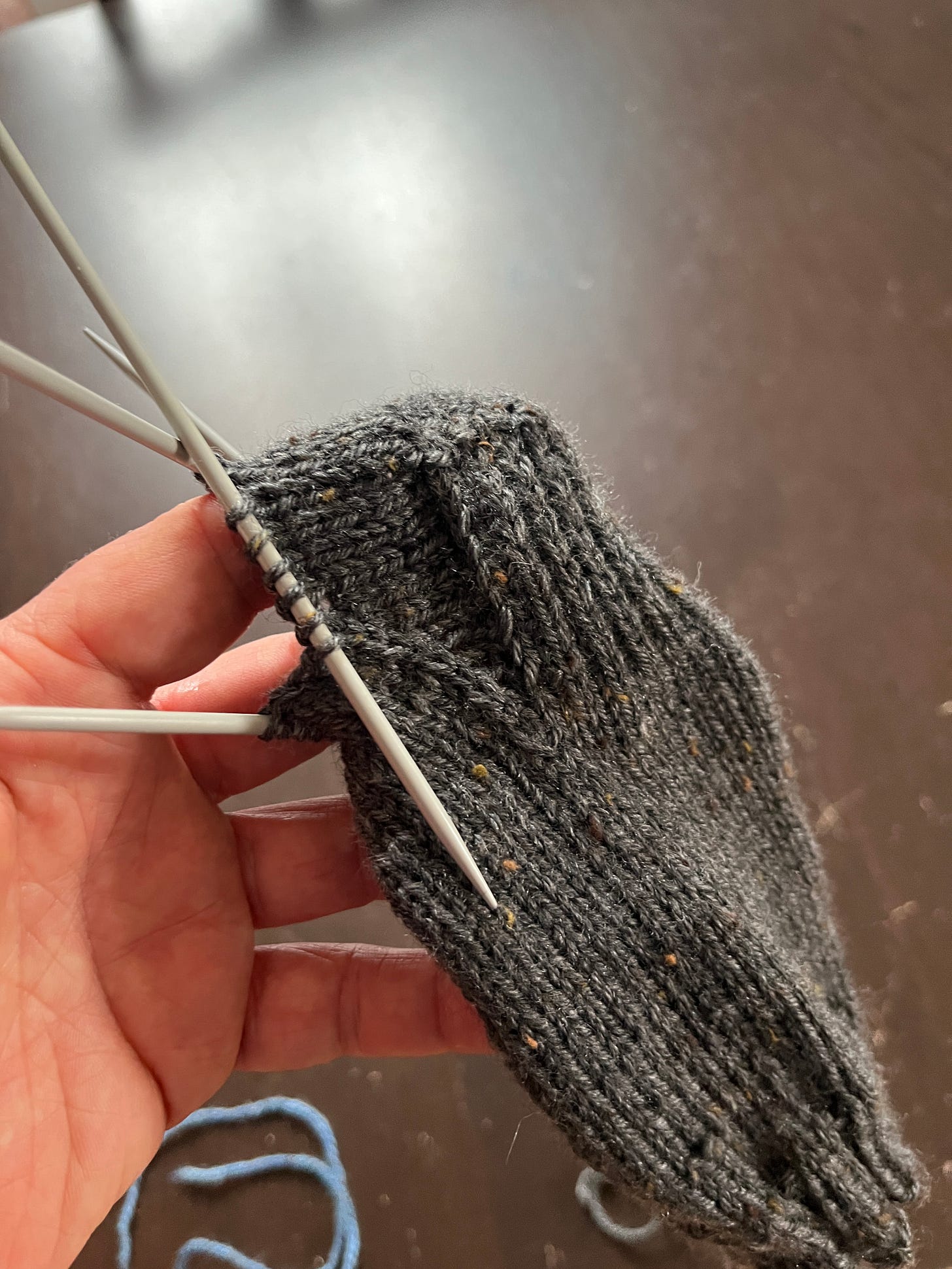 A halfway knit grey sock on knitting needles A halfway knit grey sock on knitting needles