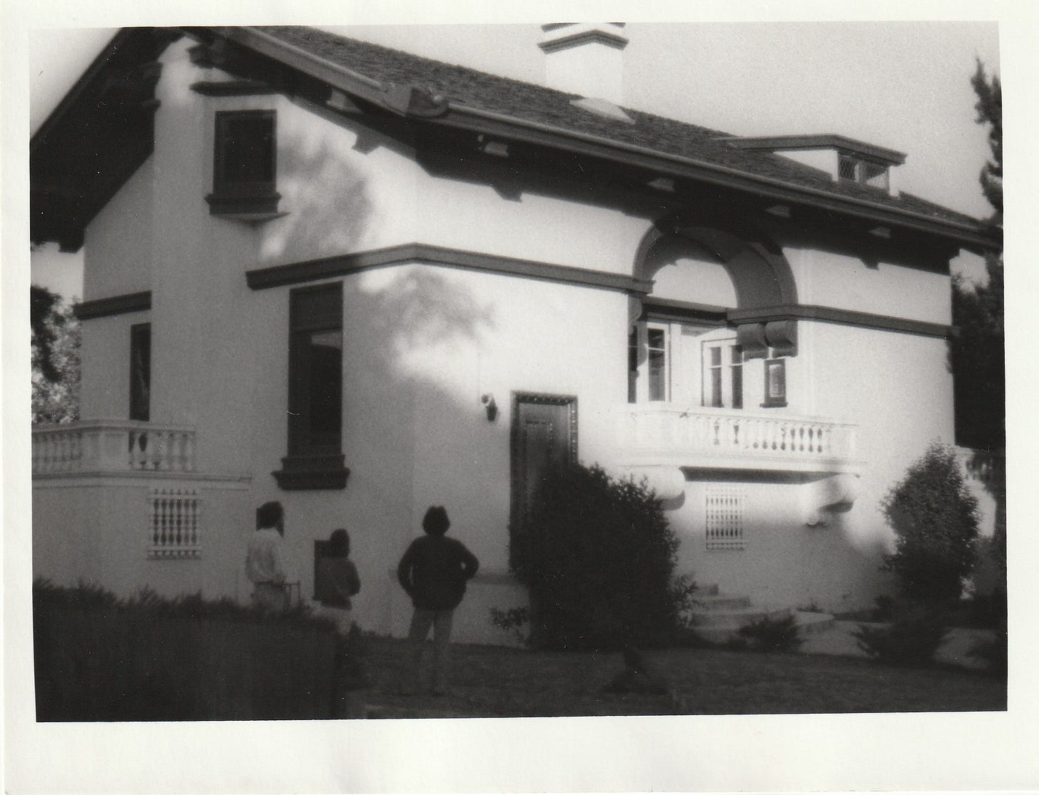 Crafstman-style house exterior with three people looking at it