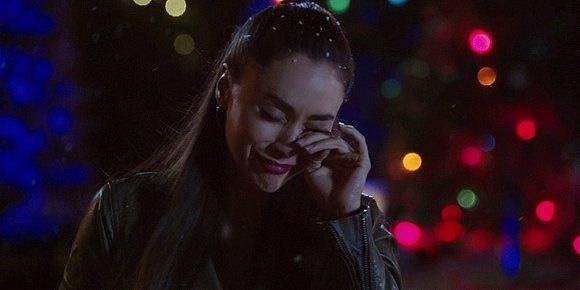 Lindsey Morgan wiping tears from eyes in front of Christmas tree. Lindsey Morgan wiping tears from eyes in front of Christmas tree.