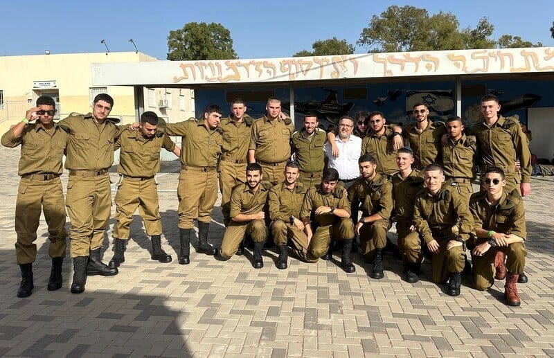 A group of soldiers outside a school A group of soldiers outside a school