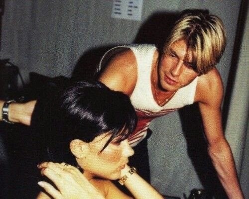 This may contain: two women are looking at each other while one is touching the back of another woman's head