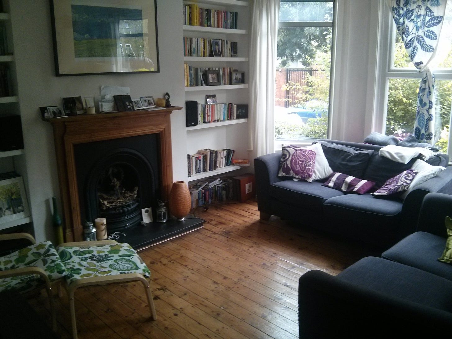 Photo of our old lounge in our Haringey flat - two sofas, wood floors, fireplace, and lots of bookshelves