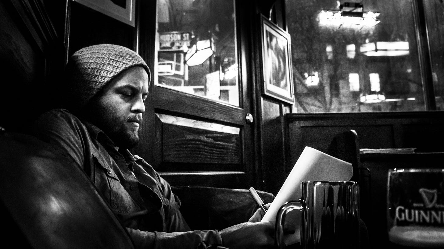 photograph of Cory Basil writing at the White Horse Tavern in New York City. Photograph taken by Donny Smutz