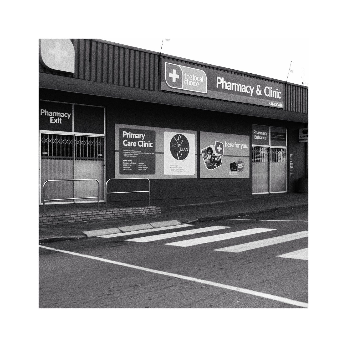 An image of a local pharmacy and clinic. Image in black and white. An image of a local pharmacy and clinic. Image in black and white.