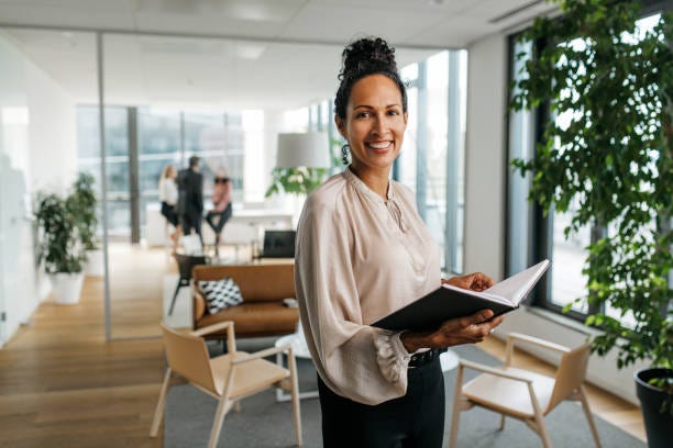 portrait d’une femme d’affaires hispanique avec organisateur personnel - femme d'affaires chatain chignon photos et images de collection