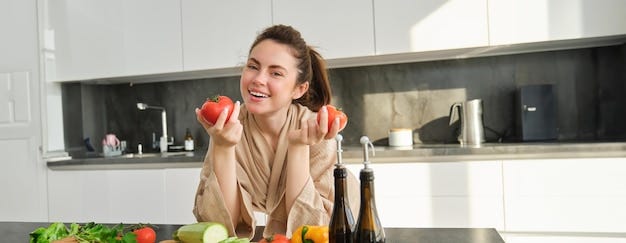 Free photo portrait of woman cooking at home in the kitchen holding tomatoes preparing delicious fresh meal Free photo portrait of woman cooking at home in the kitchen holding tomatoes preparing delicious fresh meal