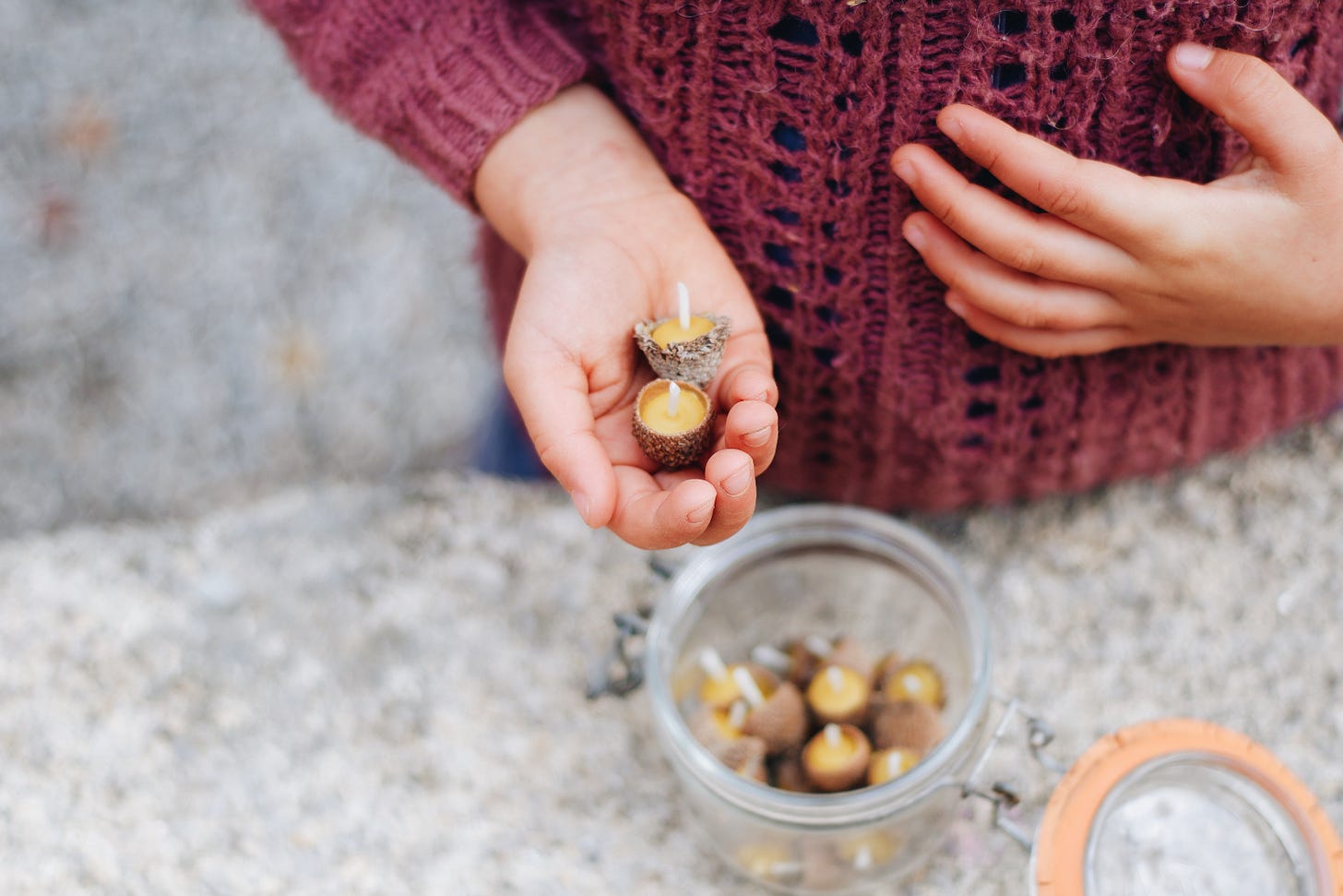 Girl holding fairy-sized acorn cap candles