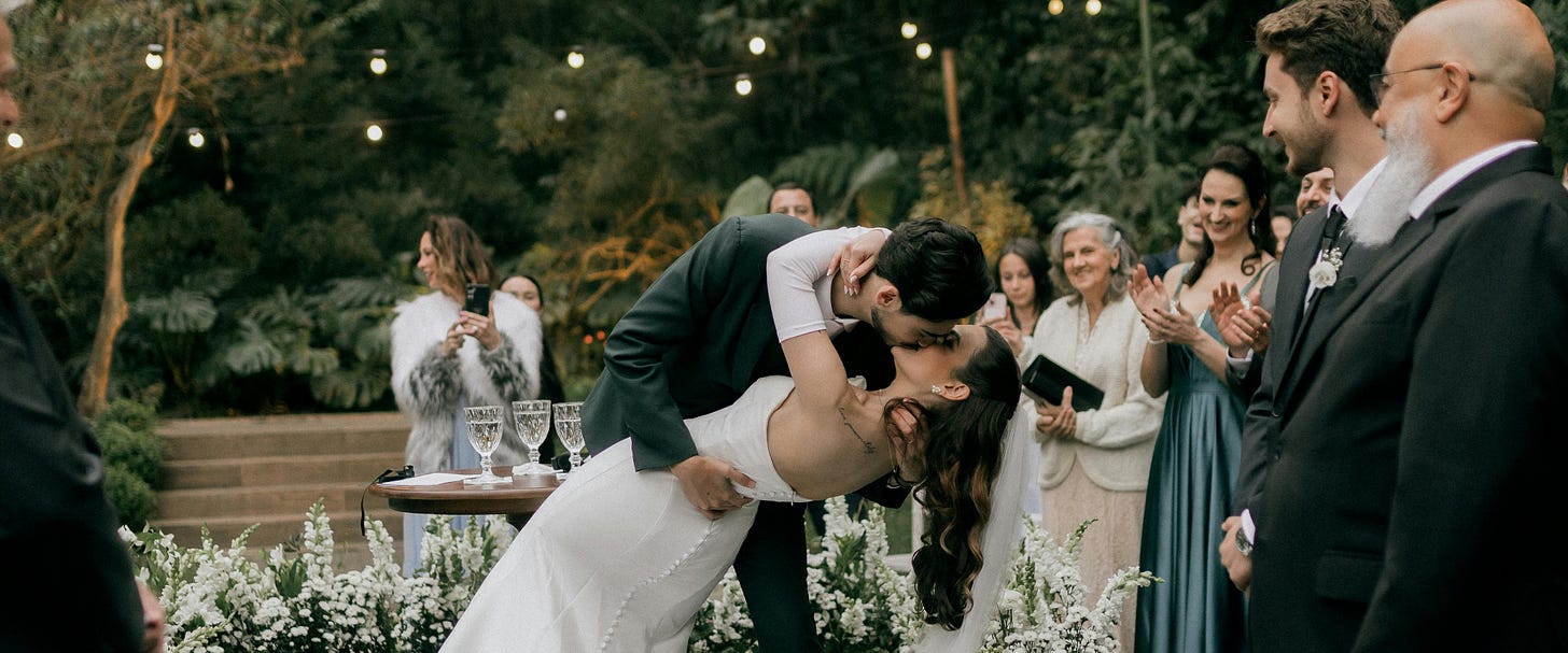 A husband kissing his bride after the wedding, holding her in his arms