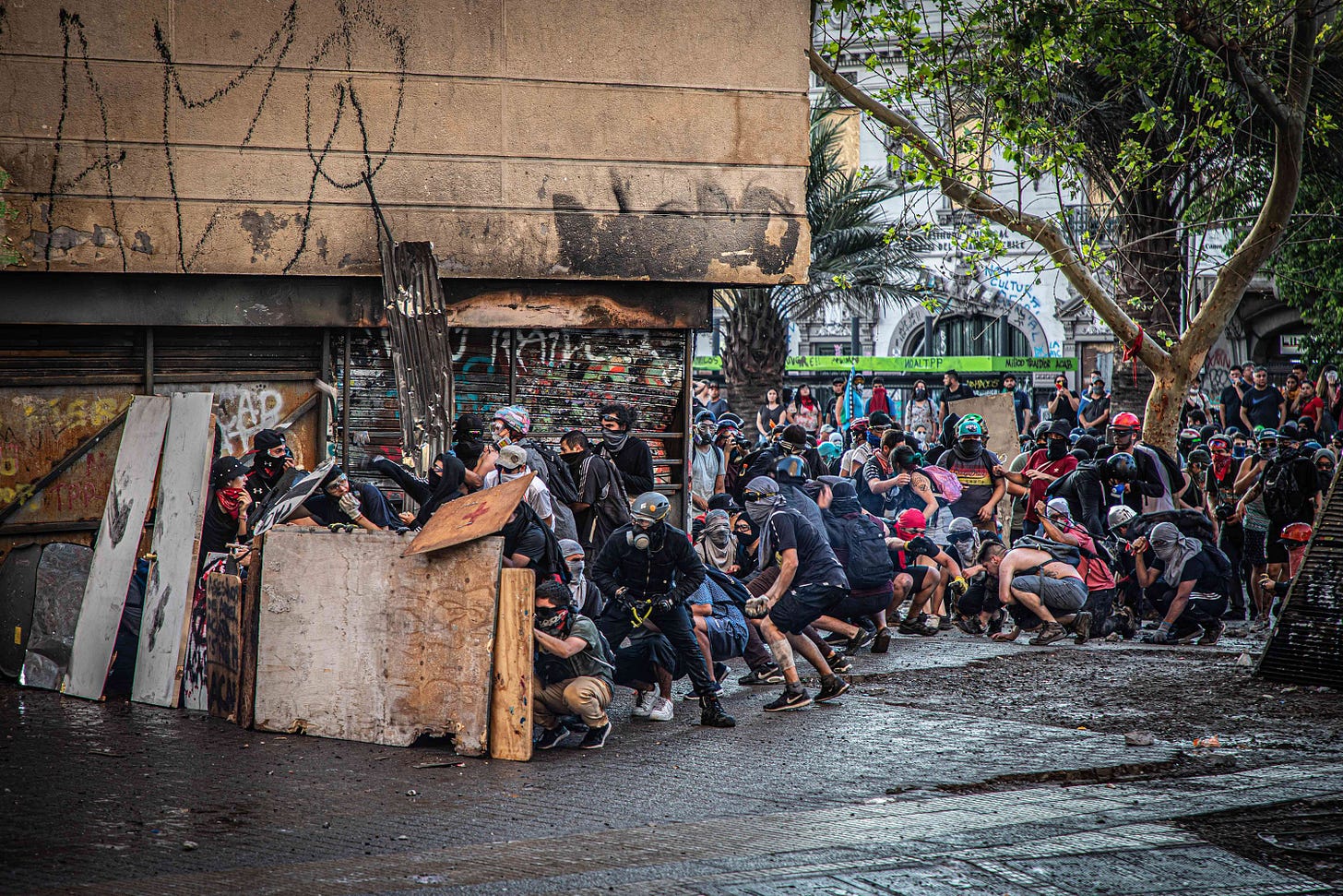 Demonstrators gather behind a barrier during a protest in Santiago, Chile, on November 18, 2019. 