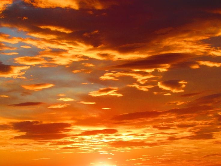 This may contain: the sun is setting behind some clouds in the sky This may contain: the sun is setting behind some clouds in the sky
