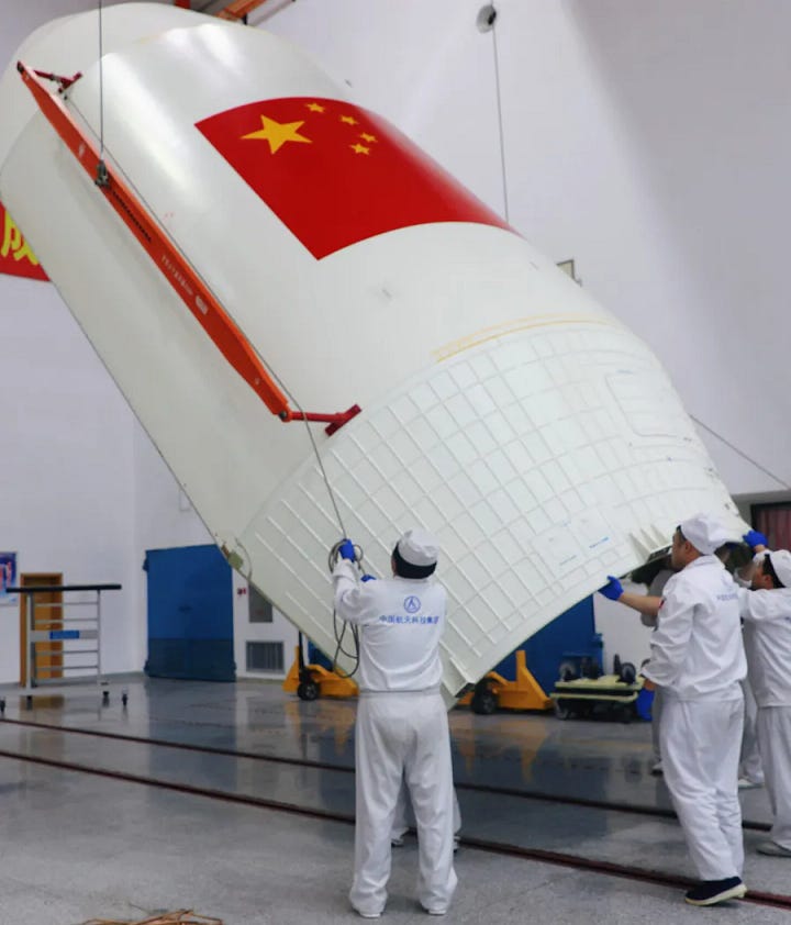 The Long March 3B/E's booster and fairing being prepared for the mission, and the ChinaSat-9C satellite being hoisted toward the top of the vehicle.