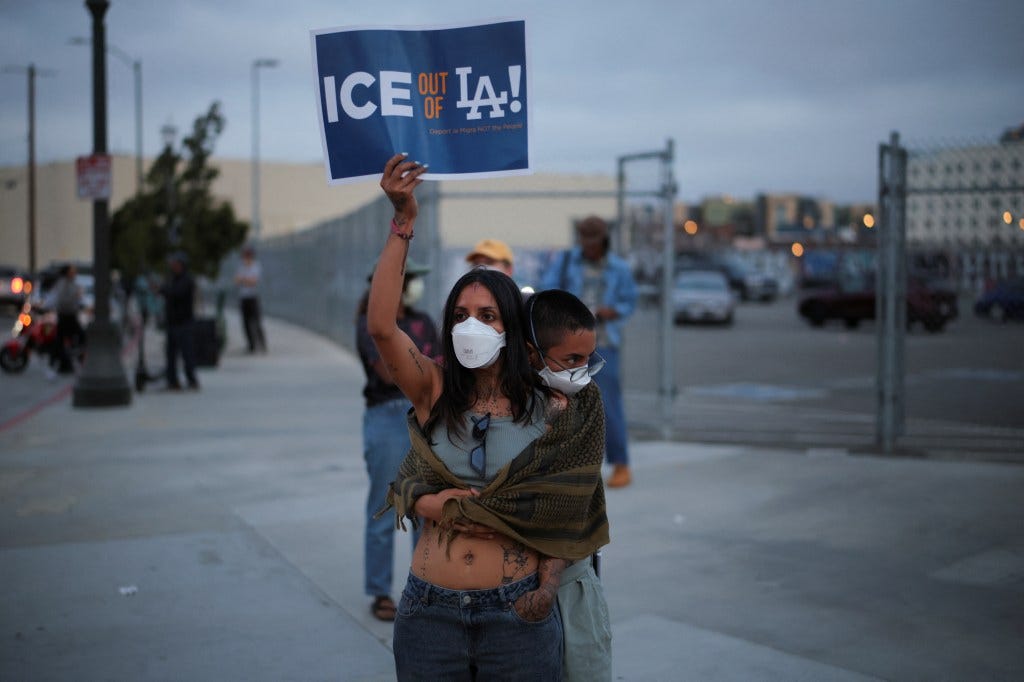 Protestors at the Los Angeles Federal Building hold a sign that reads "ICE OUT OF LA!"