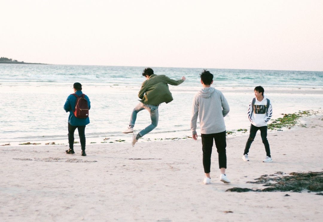 four persons near shore at daytime