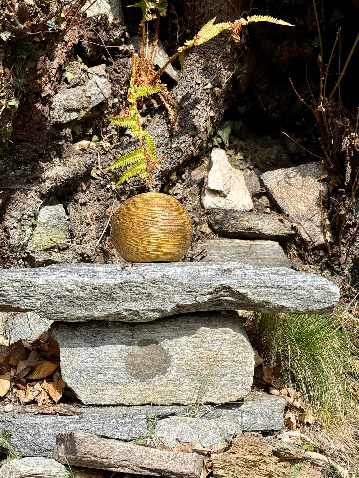 Stone altar with golden bowl and fern Stone altar with golden bowl and fern