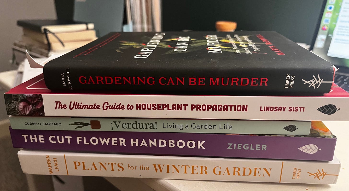 A pile of garden books on a desk A pile of garden books on a desk